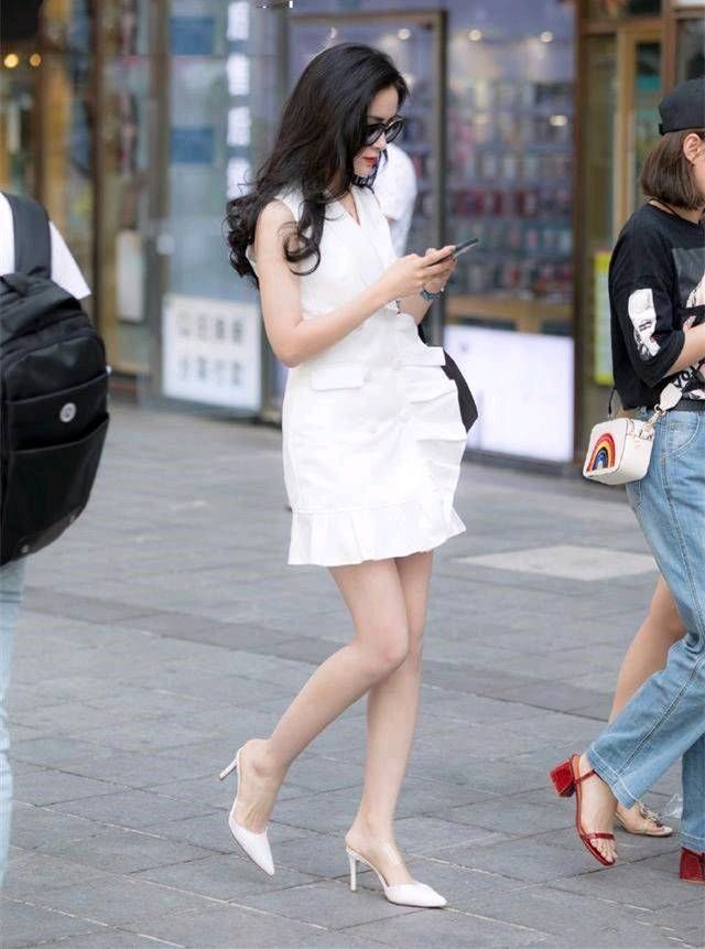 路人街拍，一身白色的连衣裙再搭配一双白色的高跟鞋，清雅又脱俗