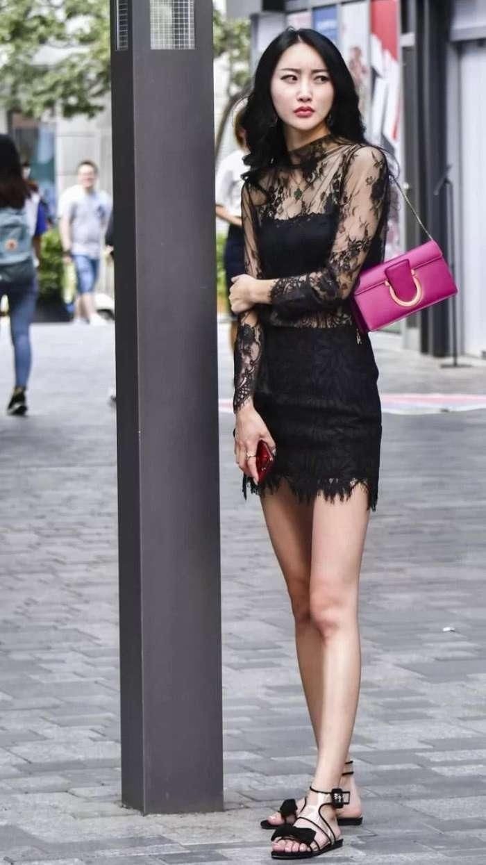 穿黑色蕾丝的美女走在大街，展现出与众不同的时尚风格