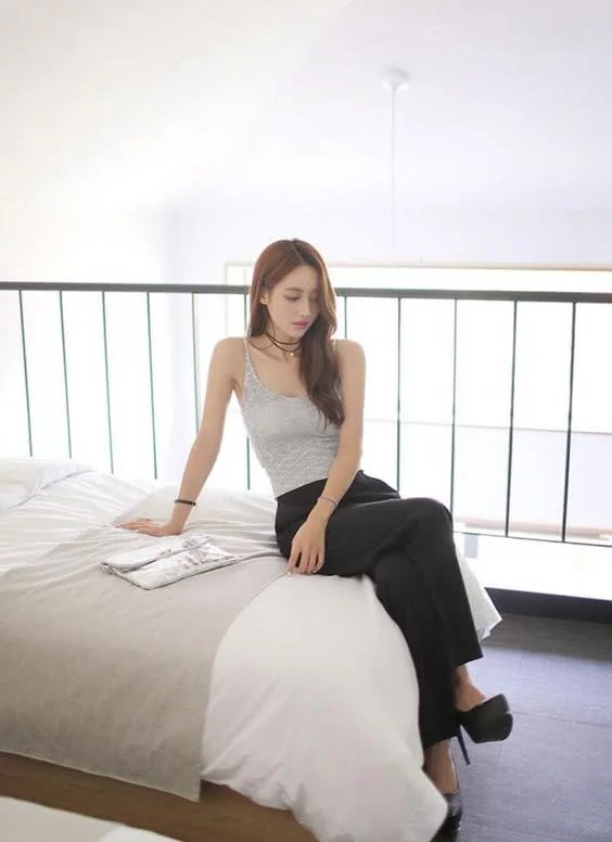 小姐姐身穿吊带上衣，搭配上黑色的修身长裤，尽显迷人的身材曲线