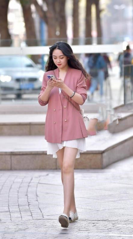  身穿：街拍：小美女身穿露肩白色T搭配一条蓝底白色斑点的短裙，偷偷一笑很清纯
