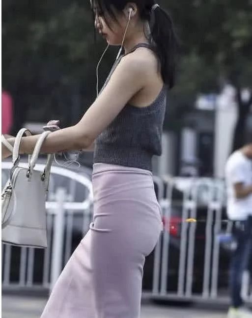 街头穿着时尚的美女,高腰包臀裙把身材比例拉伸的不错