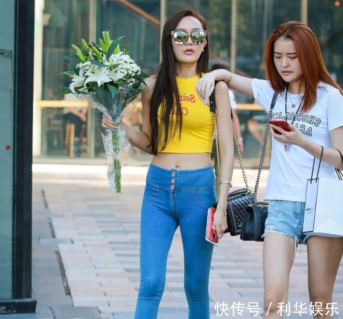 痞子型小姐姐紧身牛仔裤紧紧包裹臀部，勒出性感弧线，走在街头很