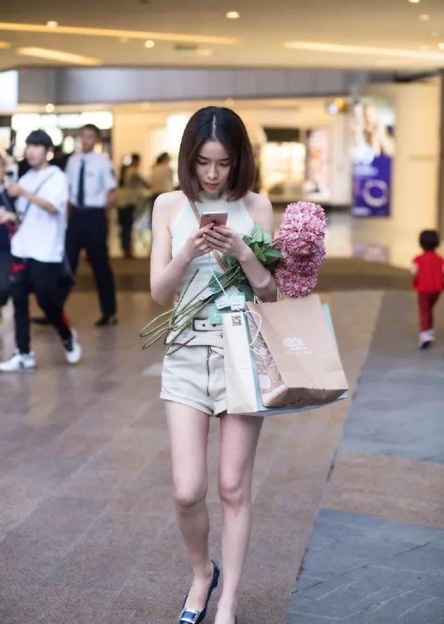 【美女】街拍:美女身穿吊带衫配牛仔短裤,很洋气,也很有格调