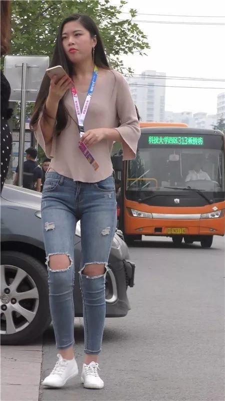 街拍美女：在街边等车的紧牛长发俏丽美女