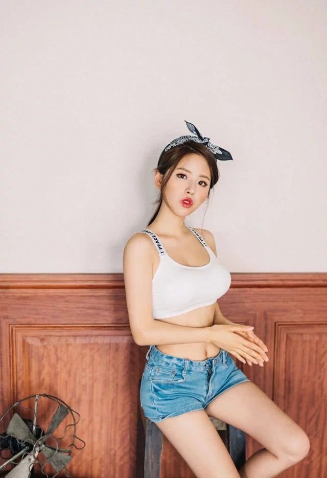 小姐姐牛仔短裤搭配紧身衣，坐在长椅上，火光映照之下，容色晶莹