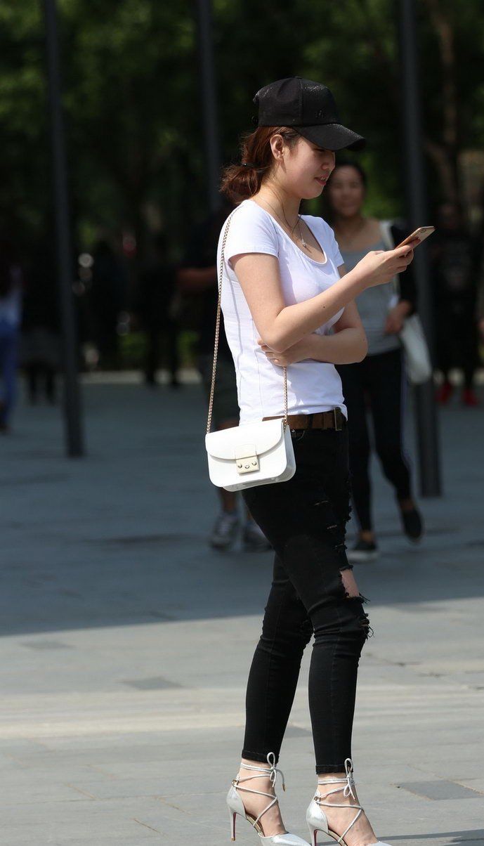 环城公园街拍:破洞牛仔裤美女，展现出成熟稳重的气质