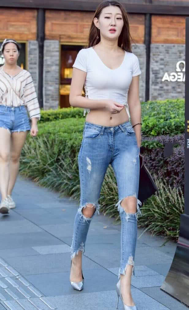 时尚小姐姐破洞牛仔裤显出修长的美腿，臀部很是浑圆，腿玩年