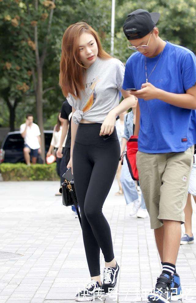 街拍：紧身黑裤搭配灰色短袖卡通上衣的水蛇腰小姐姐，身材真好