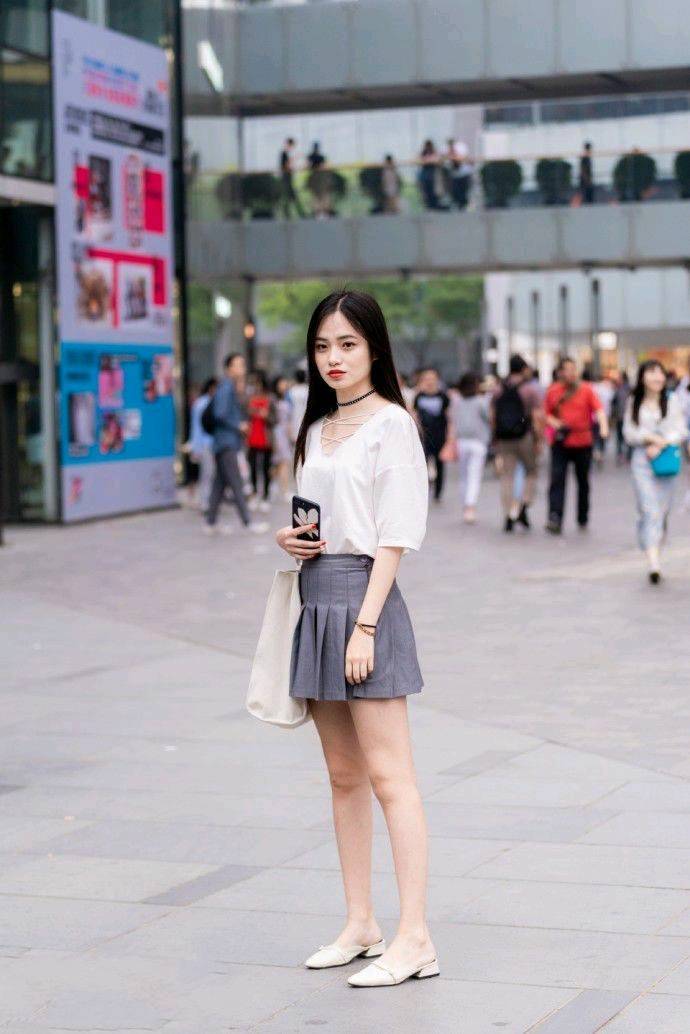 美女粉红色背心搭配白色性感短裙，身材丰满，时尚又性感！