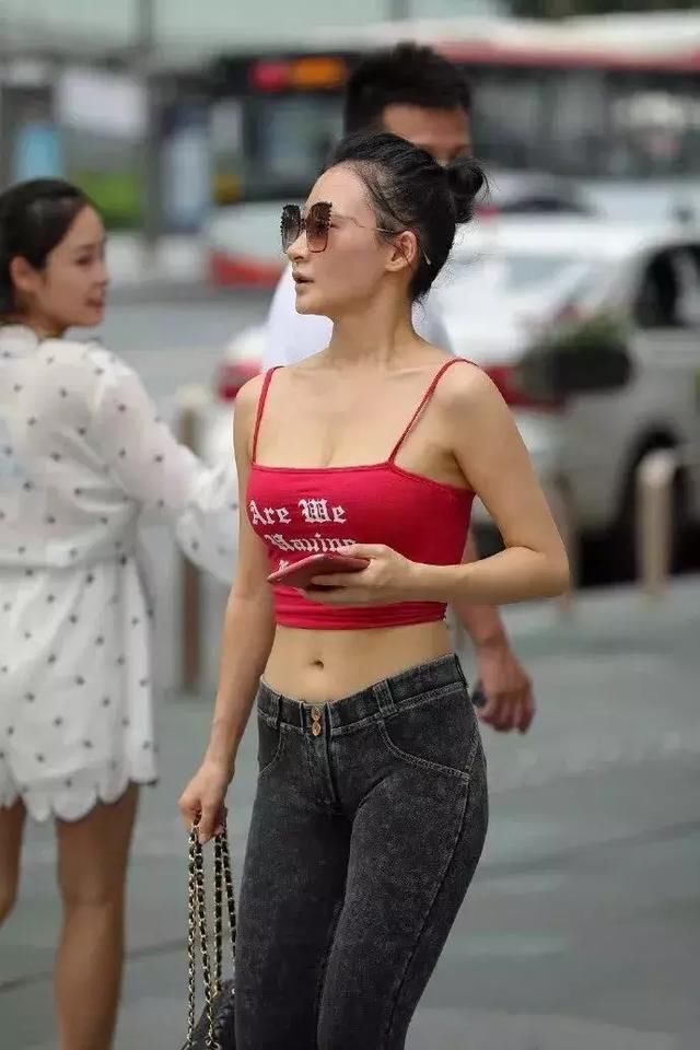 红色吊带露脐装搭配紧身牛仔裤，精致锁骨楚楚动人