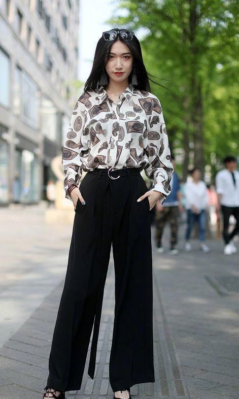 [褐色]街拍：小姐姐一件白底印着褐色图案的衬衫，搭配一件黑色的阔腿裤