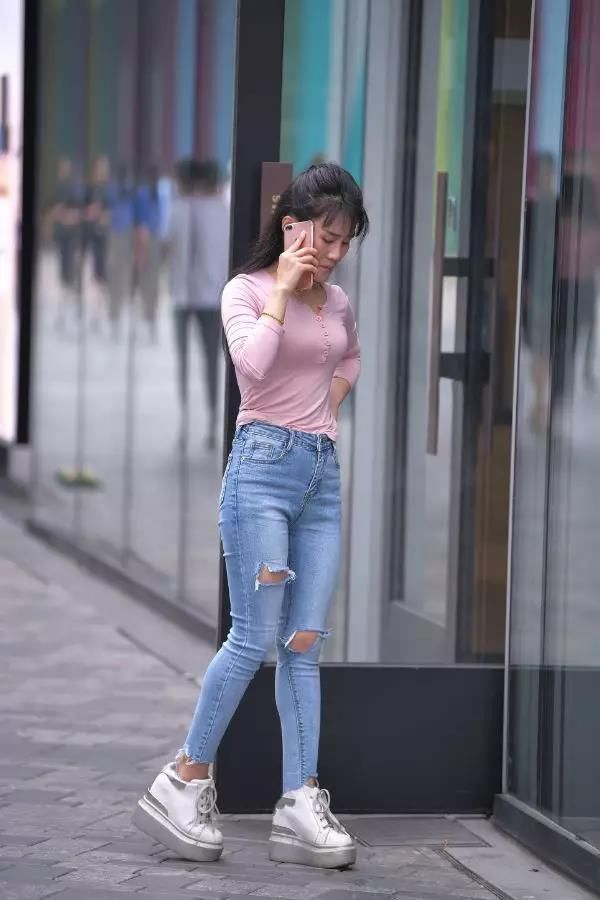街拍：打着电话，穿牛仔长裤的翘臀性感长发美女