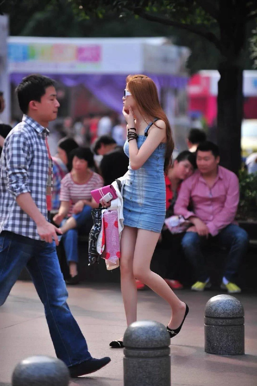 气质小姐姐蓝色牛仔吊带裙裹出曼妙好身材，齐臀裙摆秀出白皙大长