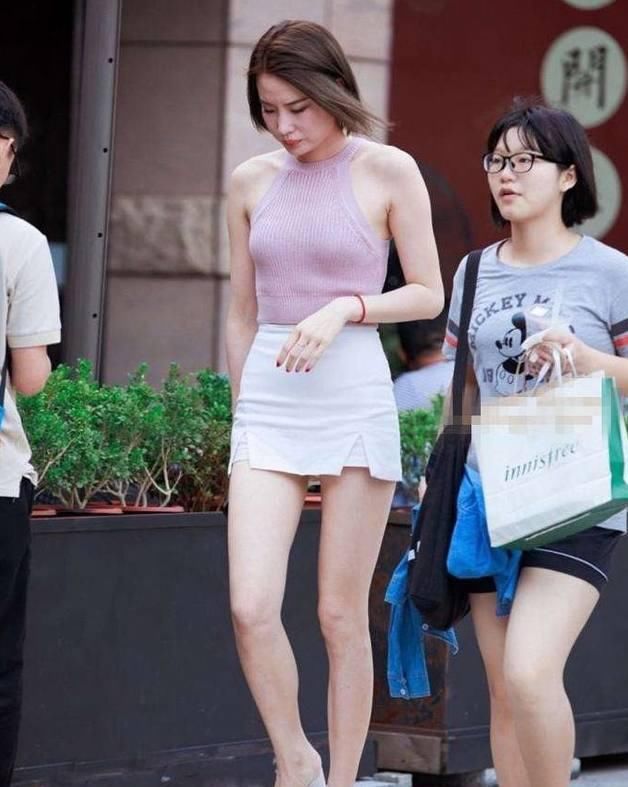 路人街拍，小姐姐时尚的穿搭带有几分妩媚和性感，十分的抢眼