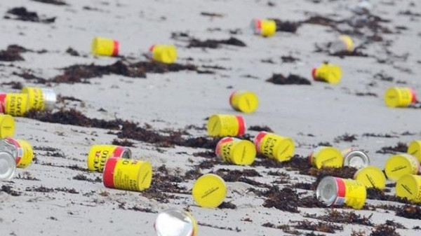 男子在沙滩游玩,海里冲上来许多黄色罐子,引来附近居民疯狂捡拾