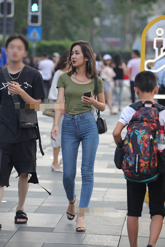 气质小姐姐清爽的紧身牛仔裤展现玲珑有致的线条，街头靓丽的风景