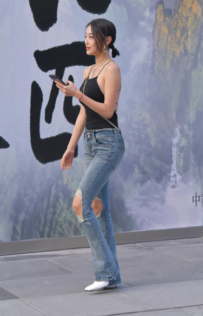 路人街拍，黑色上衣搭配牛仔裤，展示性感好身材，时尚潮流有魅力