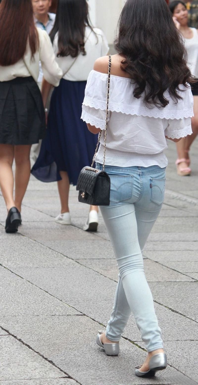 街拍:紧身牛仔裤露肩装美女，纤细的身材引人瞩目