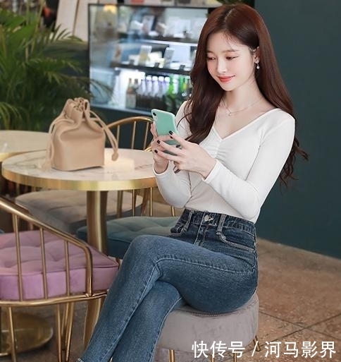 『 显得』搭配修身牛仔裤让造型更显靓丽自信,白色打底衫简洁时尚