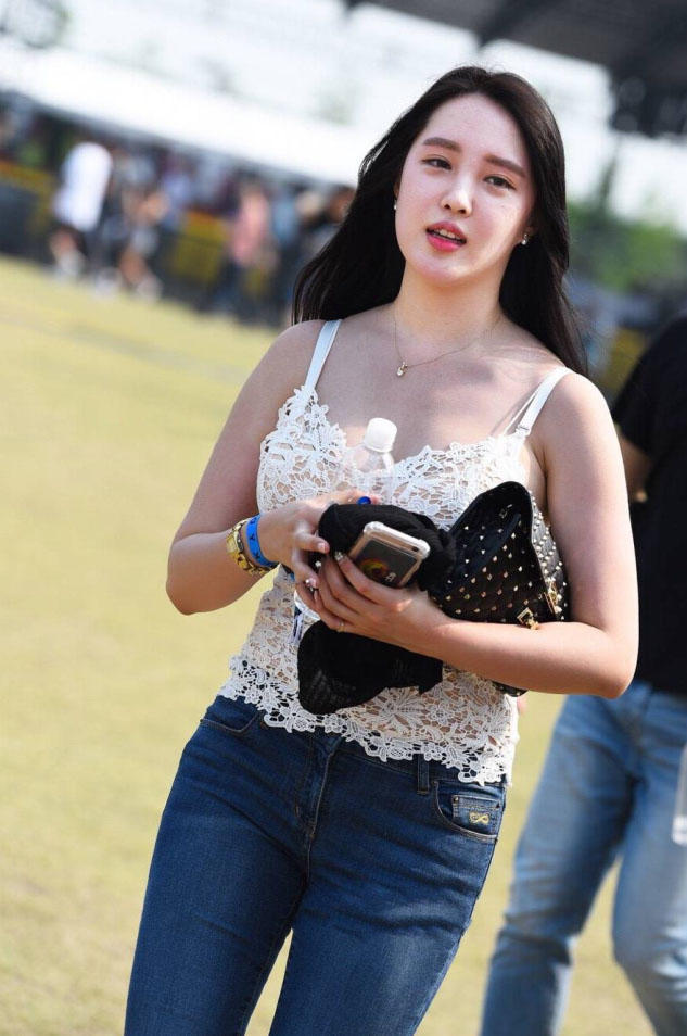 小姐姐在人群中很显眼，上边一件白色的蕾丝吊带，有点镂空的设计