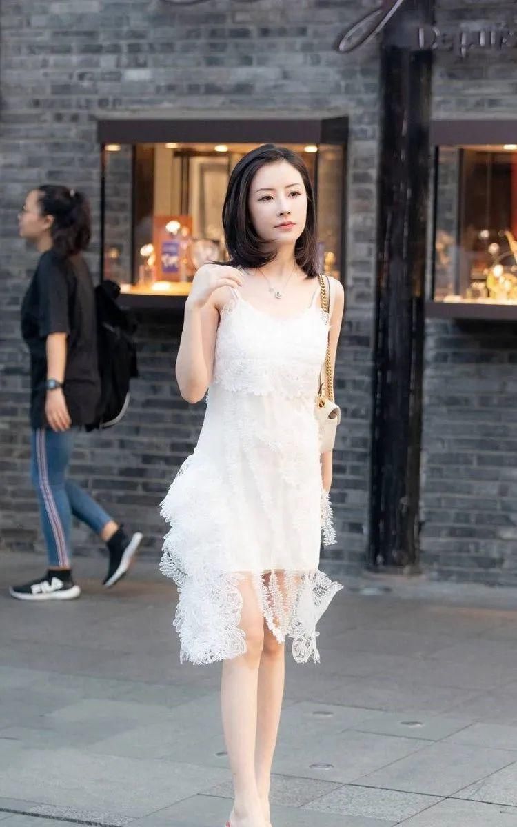  『显得』小姐姐一款白色吊带裙，裙身加上了镂空设计，显得美丽动人