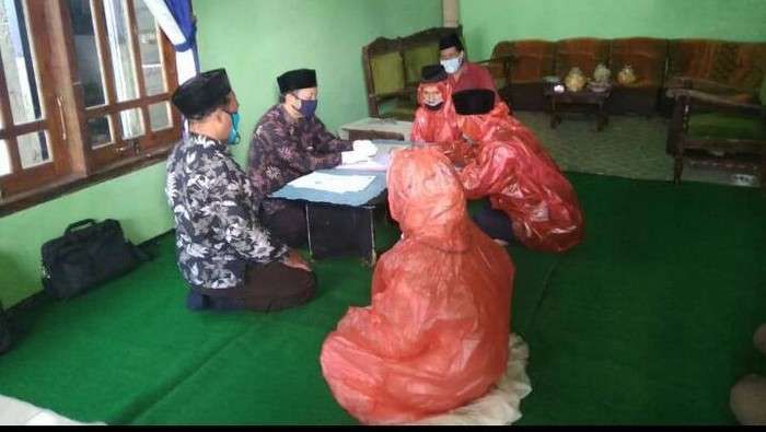  [口罩]印尼一对新人疫情期间举行婚礼:穿红色塑料雨衣,戴口罩手套