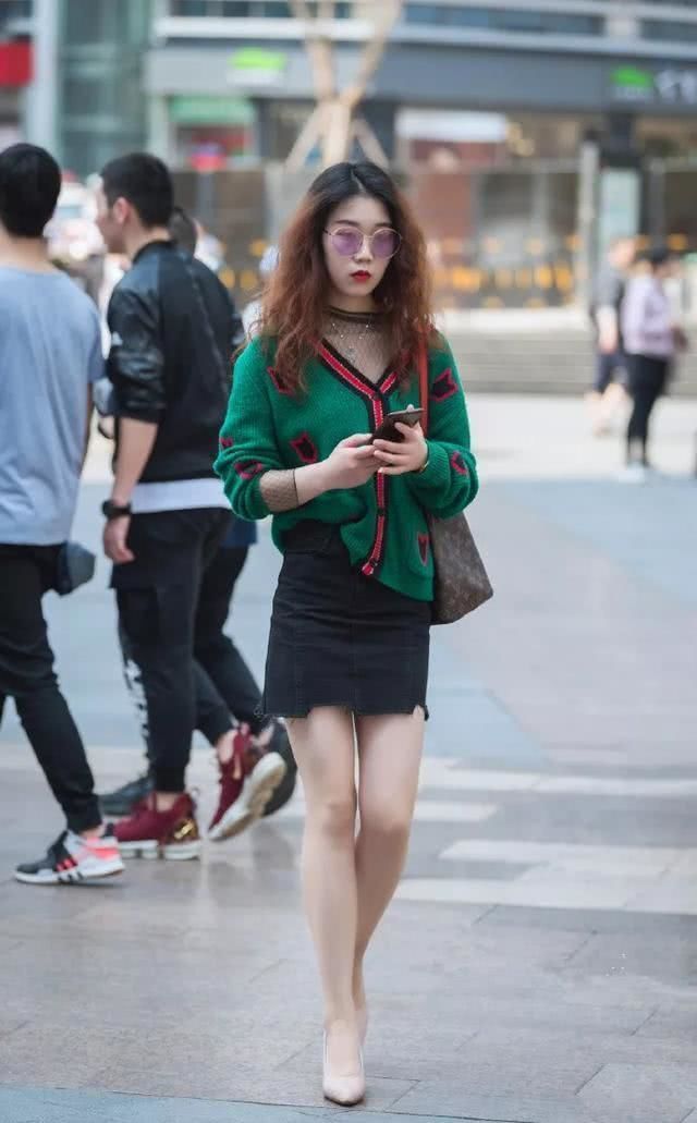 【乖巧】街拍:小姐姐扎着一个丸子发型,头戴一对绿色的耳环,乖巧秀美