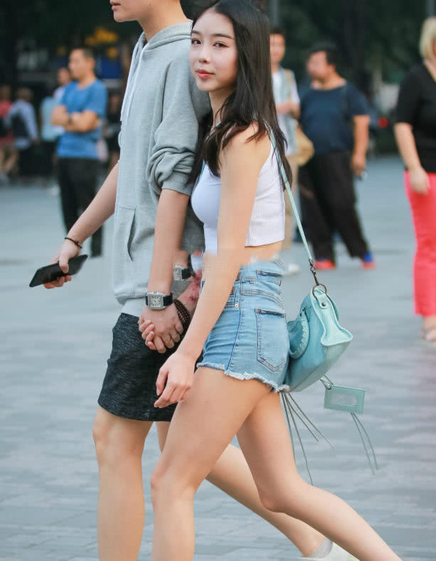 甜美小姐姐露脐装秀出白皙小蛮腰，超短裤裹出浑圆曲线，丸子头俏