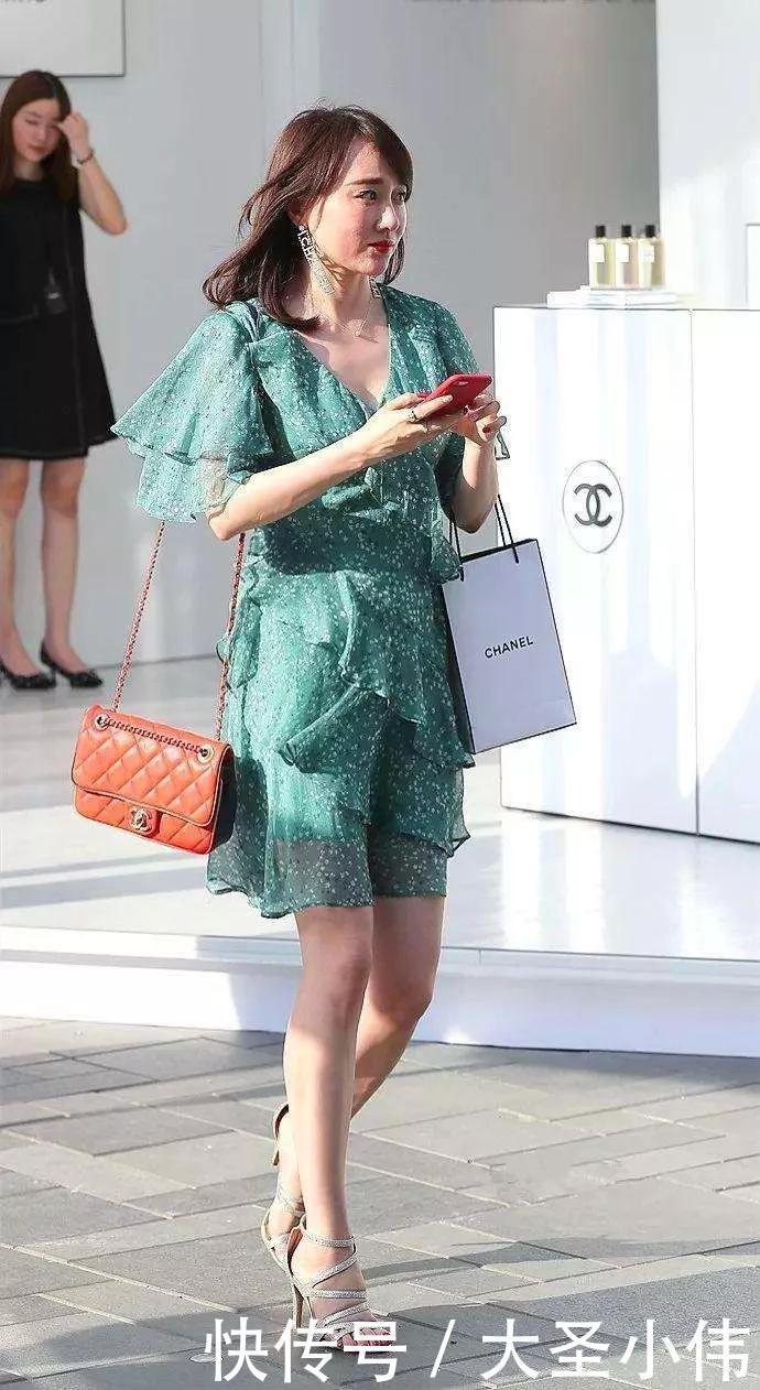 【美女】美女街拍:鹅蛋的脸型,白色的背心,整体的搭配成熟又稳重,还带着迷人的气息。