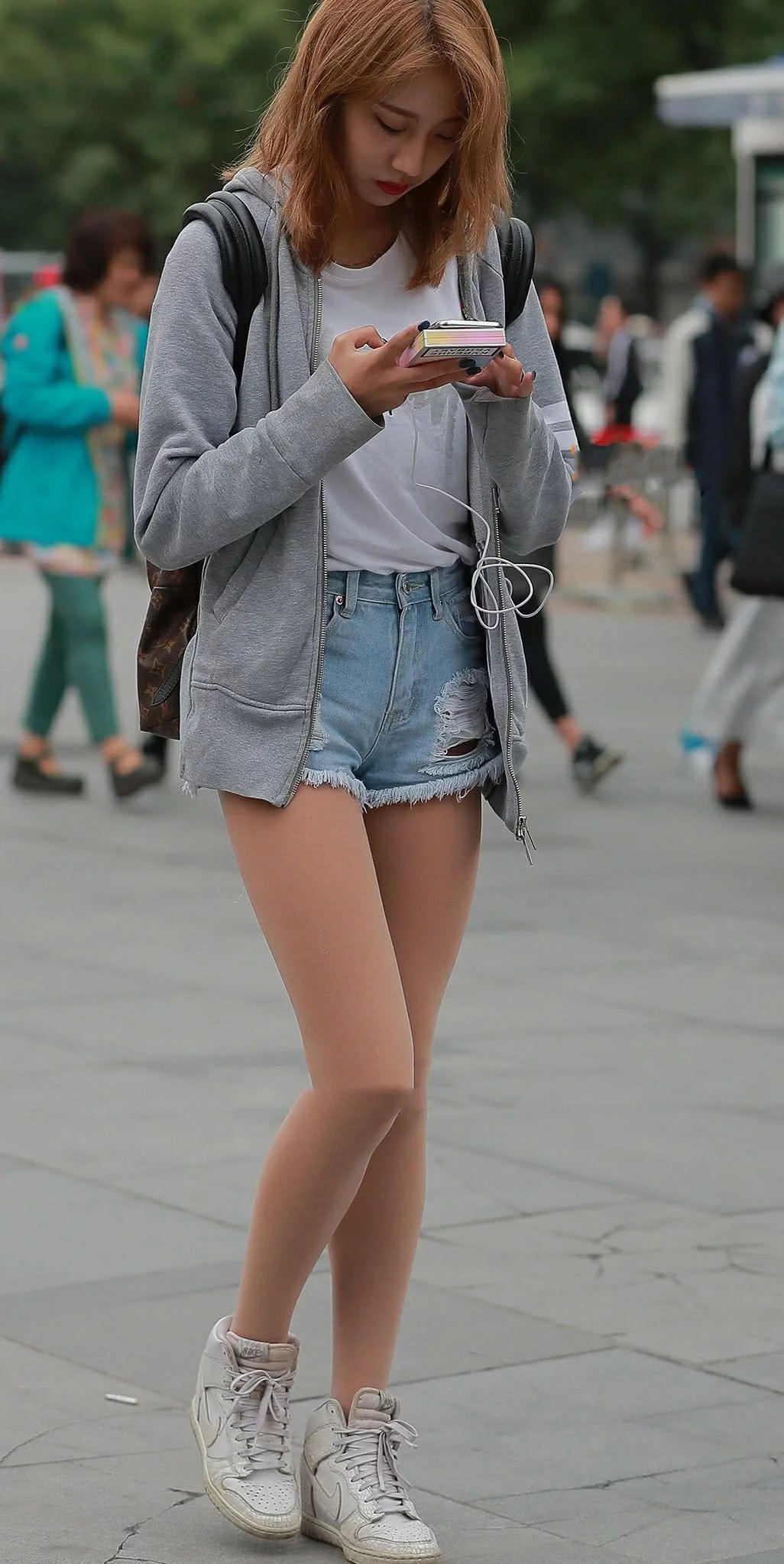 气质甜美的小姐姐蓝色短裤秀出大长腿,棕黄色秀发显得更加迷人,