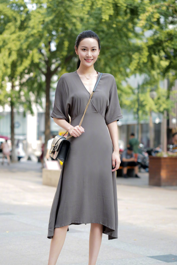 街拍：小姐姐上衣是露肚脐的设计，秀出平坦的小腹，十分性感！