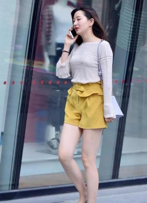  『短袖』街拍：美女身穿黑色的短袖，搭配着天蓝色的牛仔裤，很完美