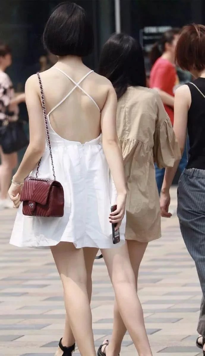 拿手机的小姐姐身穿雪白连衣裙，销魂的背景迷倒一群人