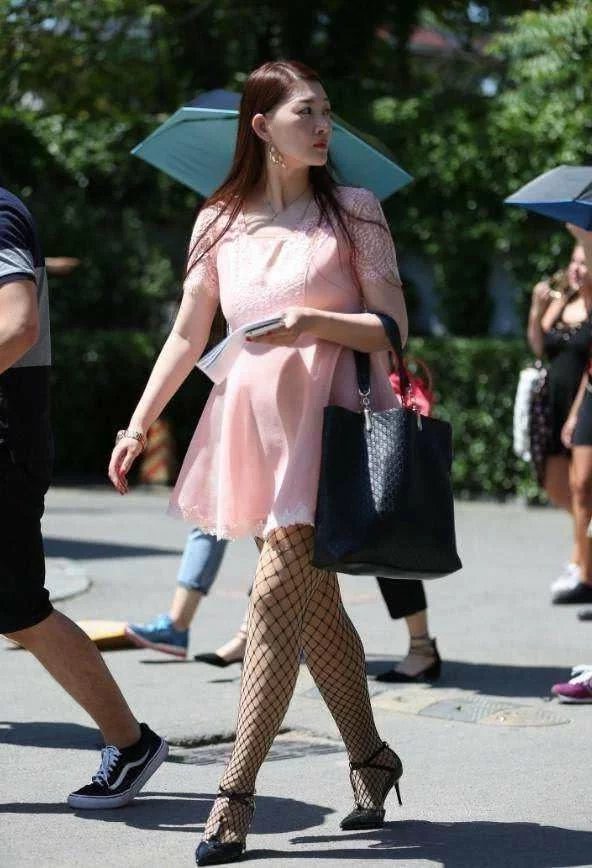 小姐姐粉色连衣裙搭配渔网袜显凹凸有致身材，下身黑色渔网袜成为