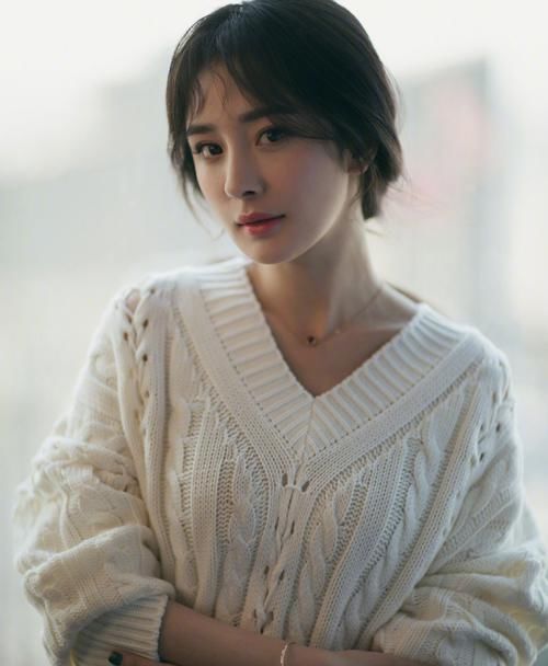  [身穿]身穿一件淡淡的绿色针织衫搭配一条休闲的白色裤子
