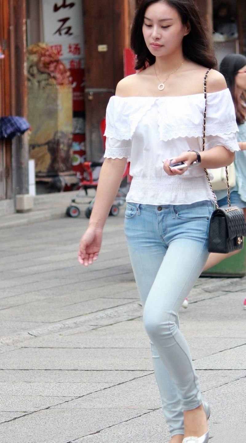 街拍:紧身牛仔裤露肩装美女，纤细的身材引人瞩目
