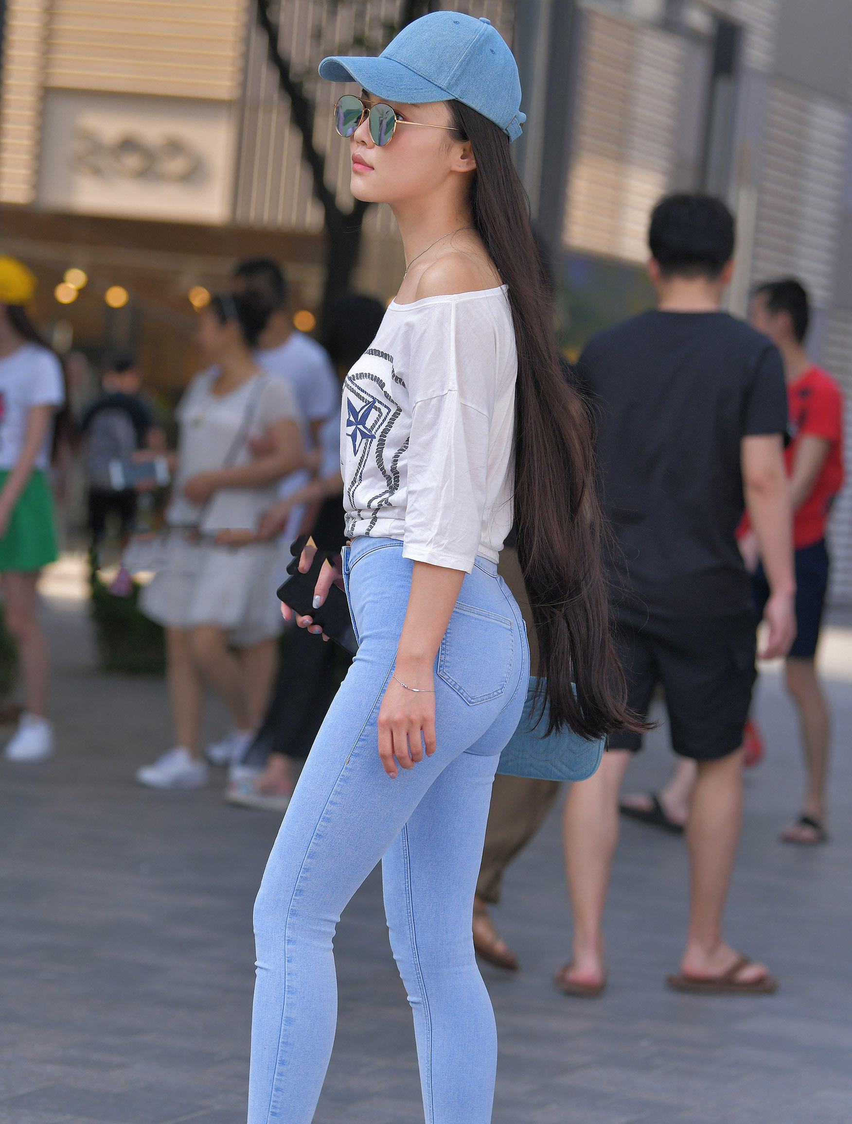 气质小姐姐长发过臀人群中很吸睛，蓝色紧身裤秀出她独有的韵味