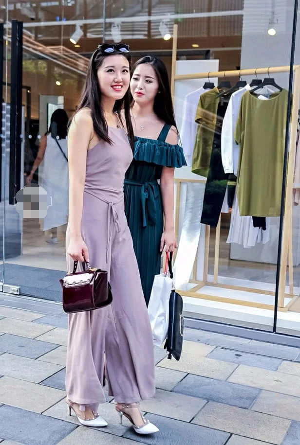 优雅时尚姐妹花漫步街头，修身长裙显凹凸有致身材