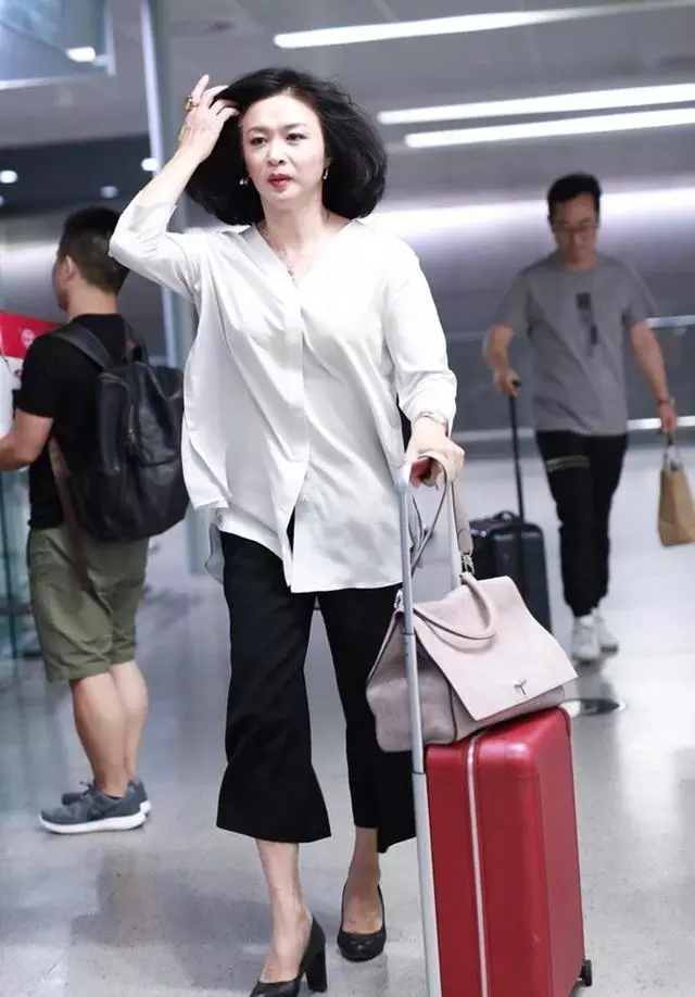 金星现身机场,只穿白衣黑裤竟如此惊艳,50岁越来越有女人味!