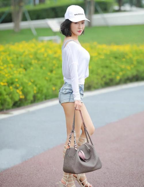 小姐姐上身搭配了一件灰色的紧身运动背心，露脐装搭配紧身牛仔裤