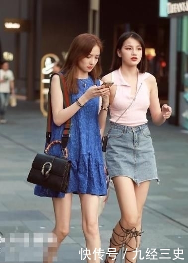 闺蜜@街拍:闺蜜逛街,一个穿蓝色无袖连衣短裙,一个V领背心配短裙