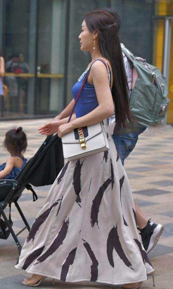 街拍：时尚辣妈蓝色吊带背心搭配白色长裙，非常的修身和性感！