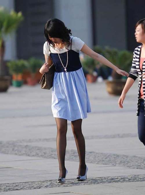 街拍：连衣裙裙下的丝袜大长腿妹子，一双细腿引人注目！