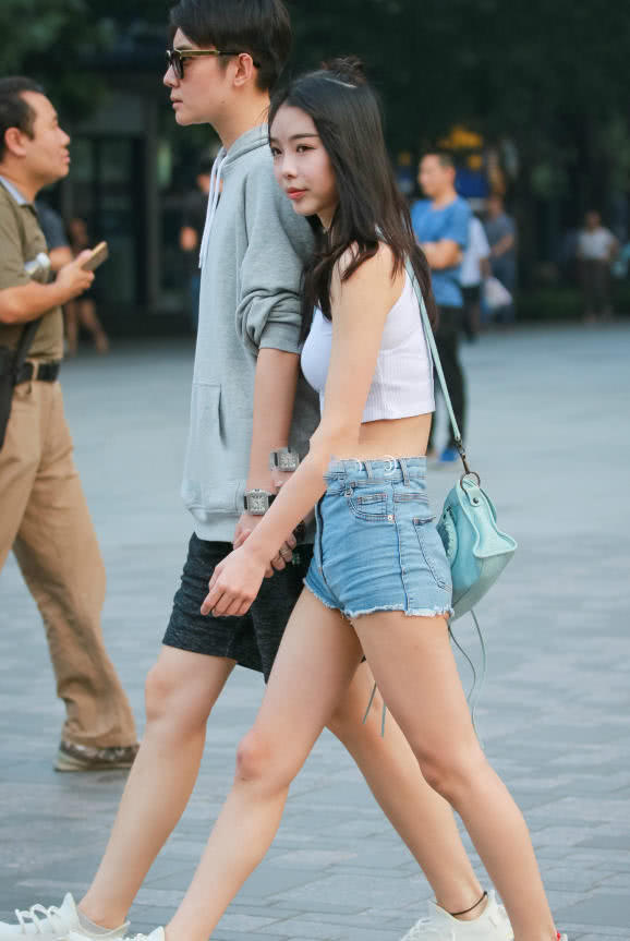 甜美小姐姐露脐装秀出白皙小蛮腰，超短裤裹出浑圆曲线，丸子头俏