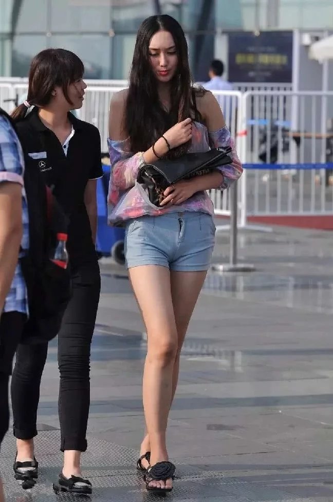火车站偶遇长发气质小姐姐，吊带抹胸装搭配紧身短裤尽显高挑迷人