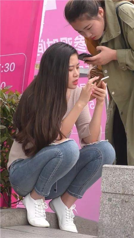 街拍美女：在街边等车的紧牛长发俏丽美女
