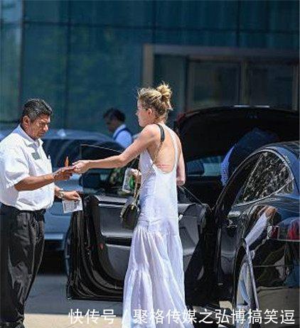 艾梅柏·希尔德穿纯白长裙大散文艺气息，街头匆忙赶行程露美背