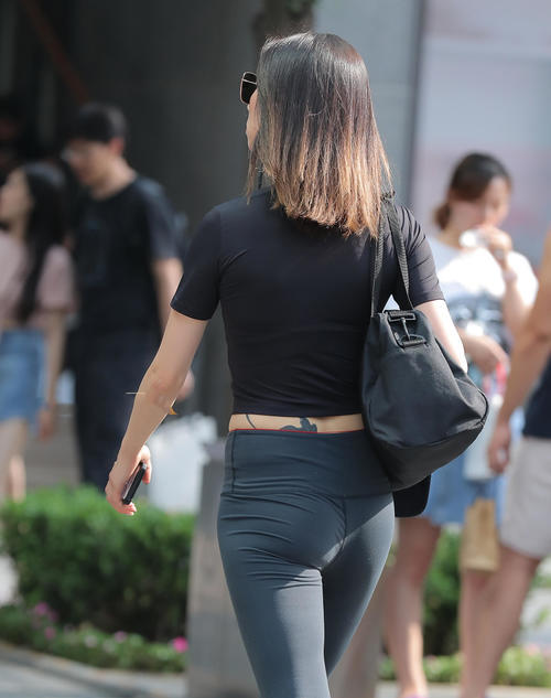 路人街拍，小姐身材丰满迷人，穿上健身服后十分的高挑迷人