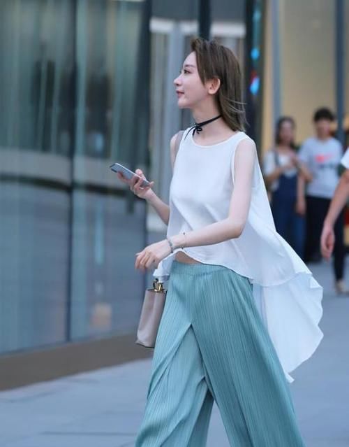  「荷叶边」街拍：气质高雅的小姐姐，一件白色上衣配蓝色休闲裤，时尚活力范