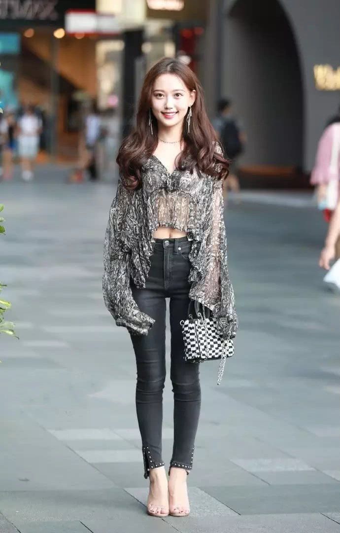 紧身牛仔裤的美女,搭配薄如纱的上衣,美丽又大方,很招人喜欢!